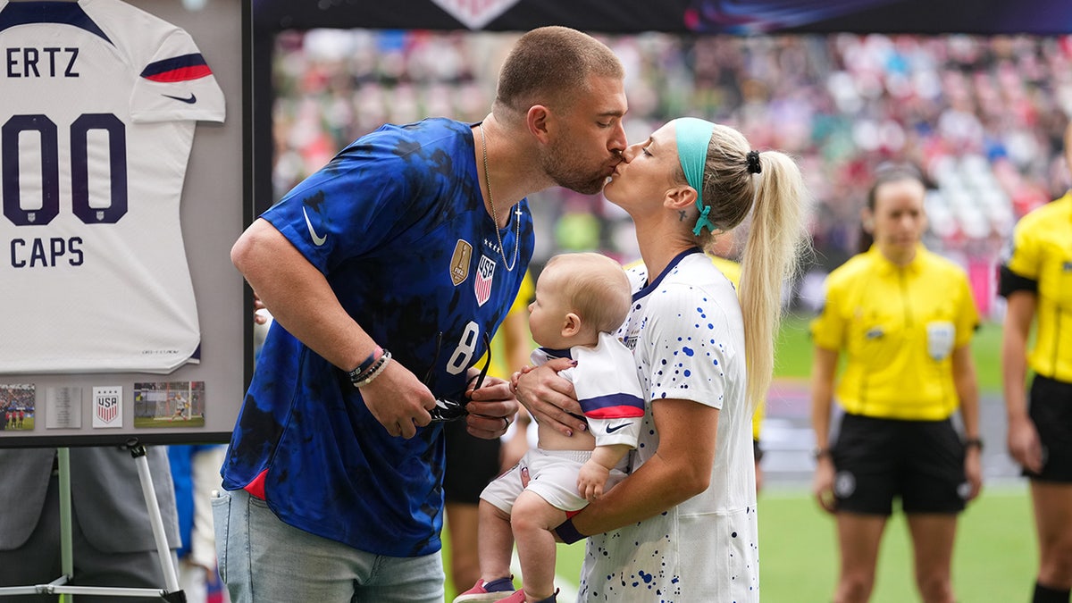 Julie and Zach Ertz kiss during ceremony on soccer pitch
