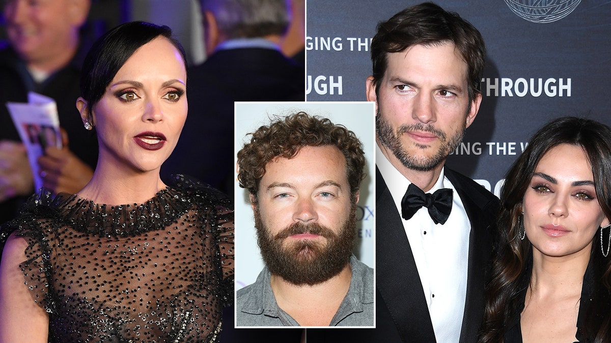 Christina Ricci in a sheer black lacy dress with a dark lip on the red carpet looks to her left split Ashton Kutcher in a tuxedo looks to his right with wife Mila Kunis next to him, in the middle Danny Masterson on a carpet