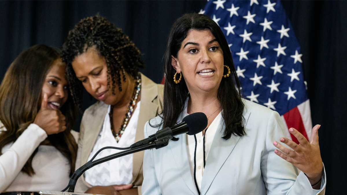 Brooke Pinto speaking at microphone