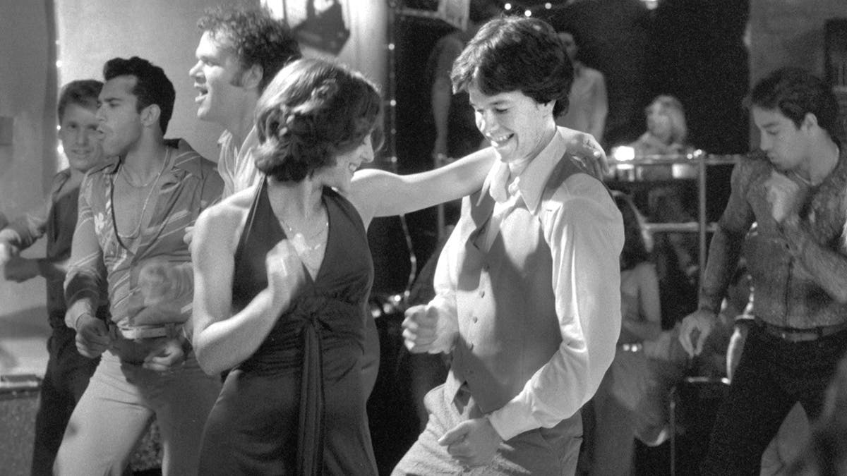 Mark Wahlberg dancing in a black and white photo of the film "Boogie Nights"
