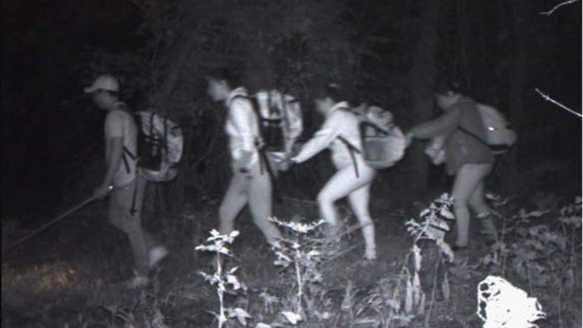 black and white image of migrants crossing border