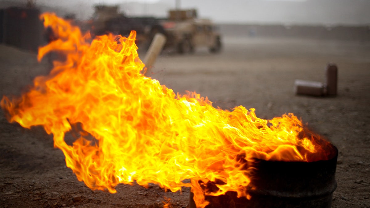 Flames pour out of burn barrel in Afghanistan