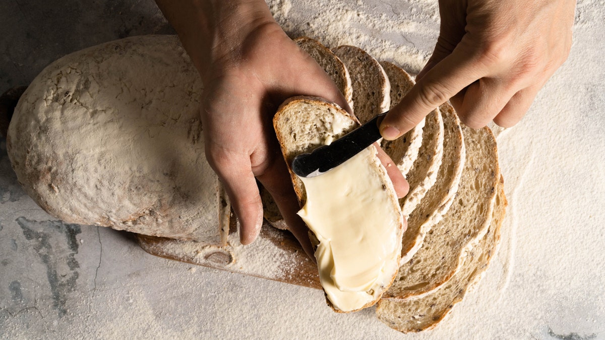 man spreading butter on bread