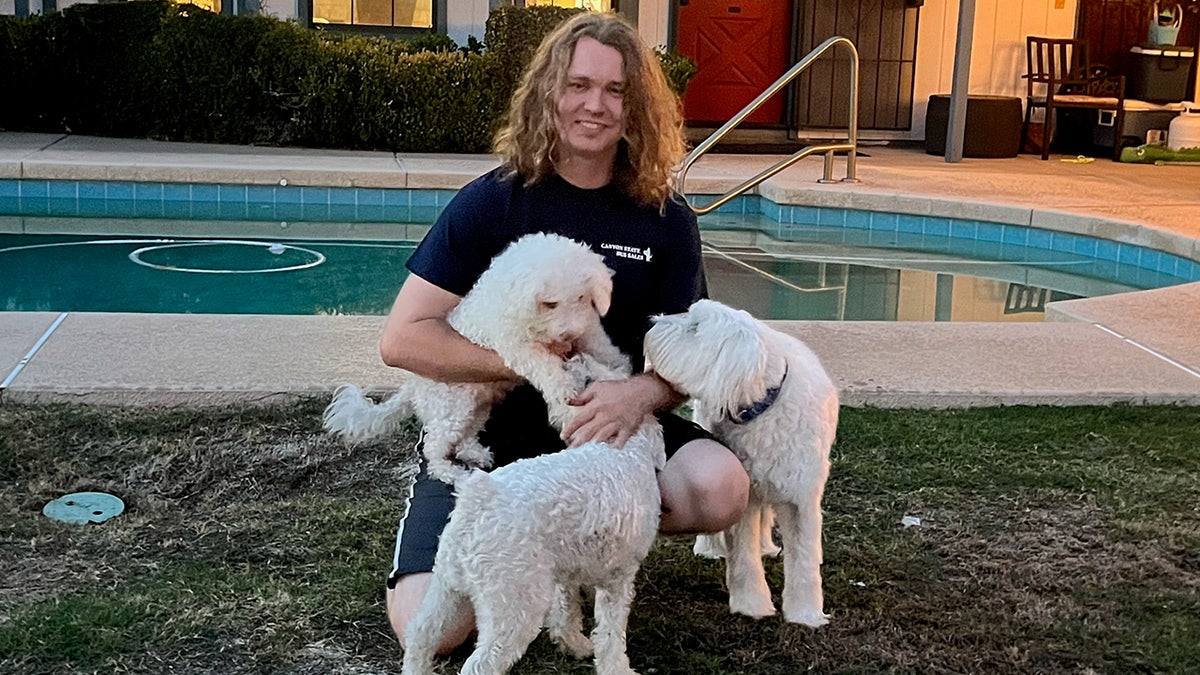 Chase Crandall holding Minion and other dogs