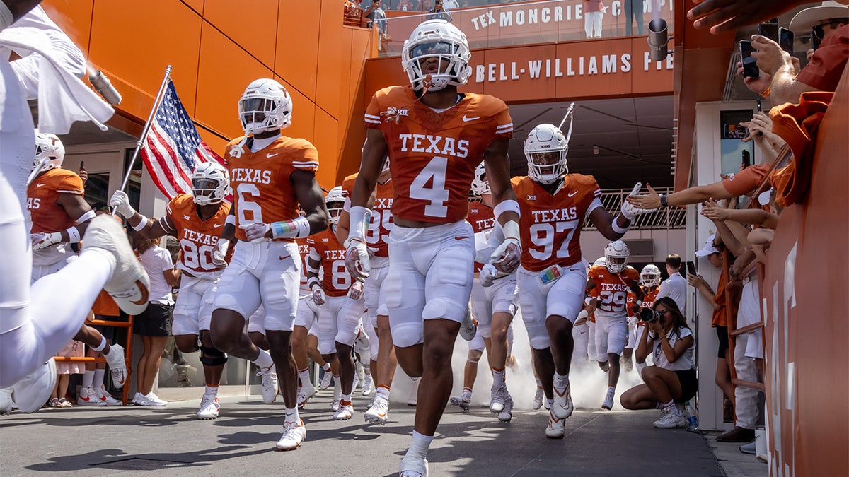 Texas Longhorns players run out of the tunnel against Rice