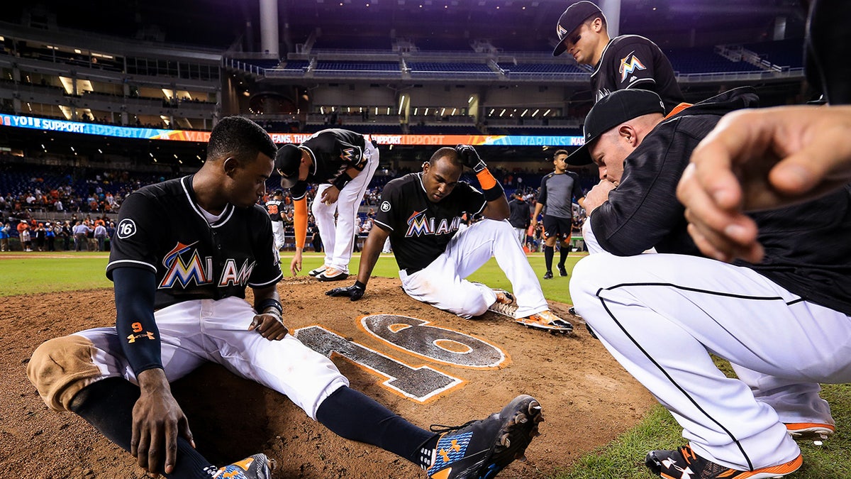 Dee Gordon sits with teammates on the mound