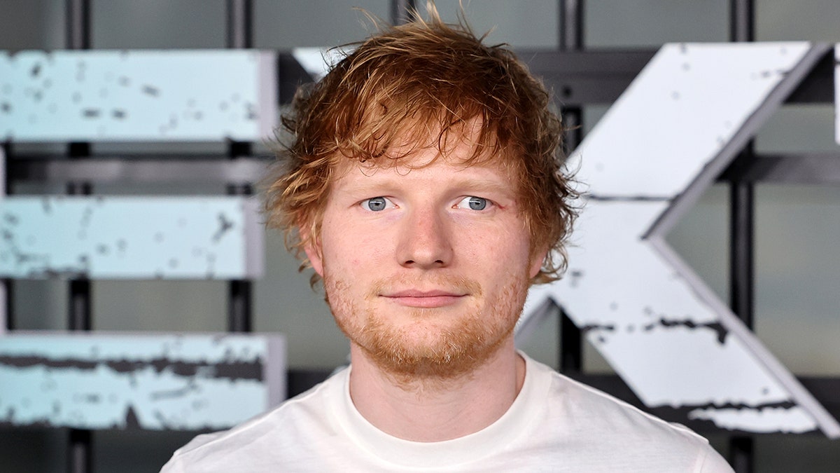 Ed Sheeran on the carpet for a film premiere in a white t-shirt