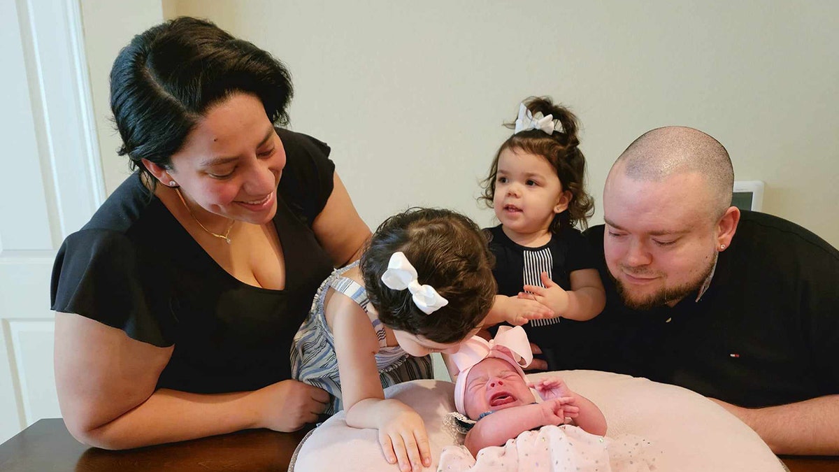 family laughing with three daughters