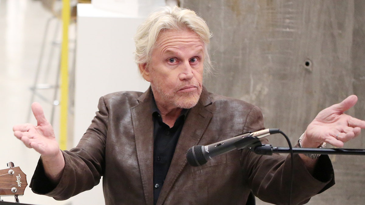 Gary Busey in a black shirt and brown leather jacket in New York City