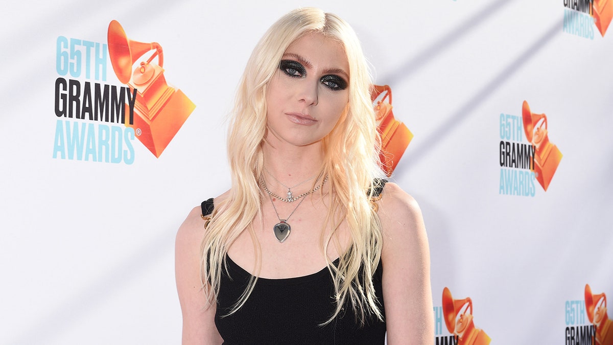 Taylor Momsen tils her head slightly to the left on the carpet in a black outfit with heavy black eye makeup in Los Angeles