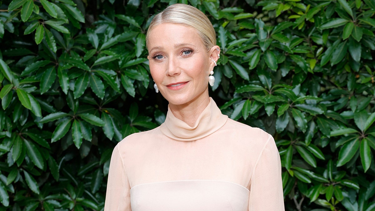 Gwyneth Paltrow standing in front of a grass wall