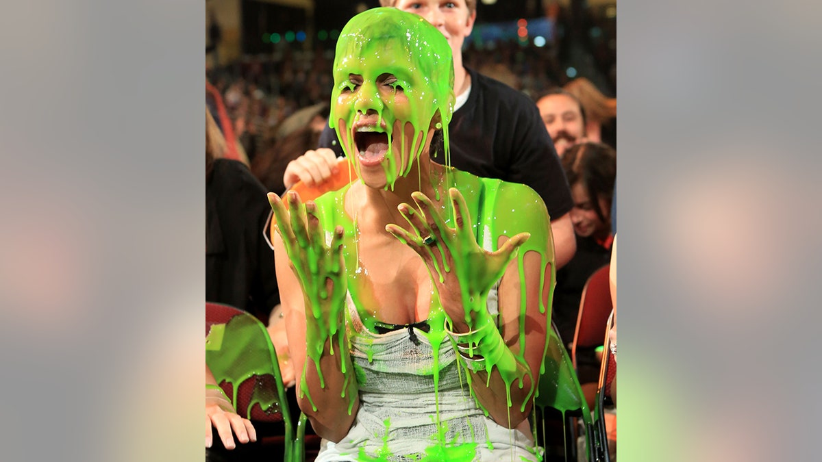 Halle Berry covered in slime putting up both her hands in shock at the Kids' Choice Awards
