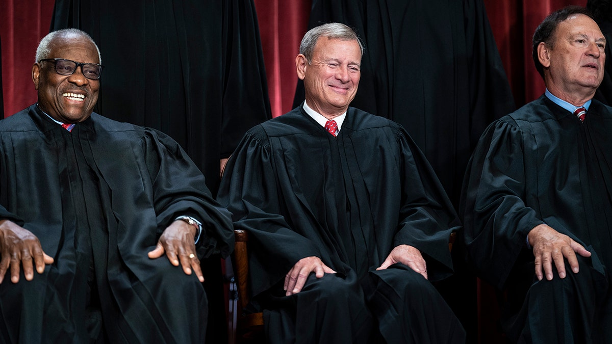 Justices Thomas, left, and Alito, right, with Chief Justice Roberts center in photo session