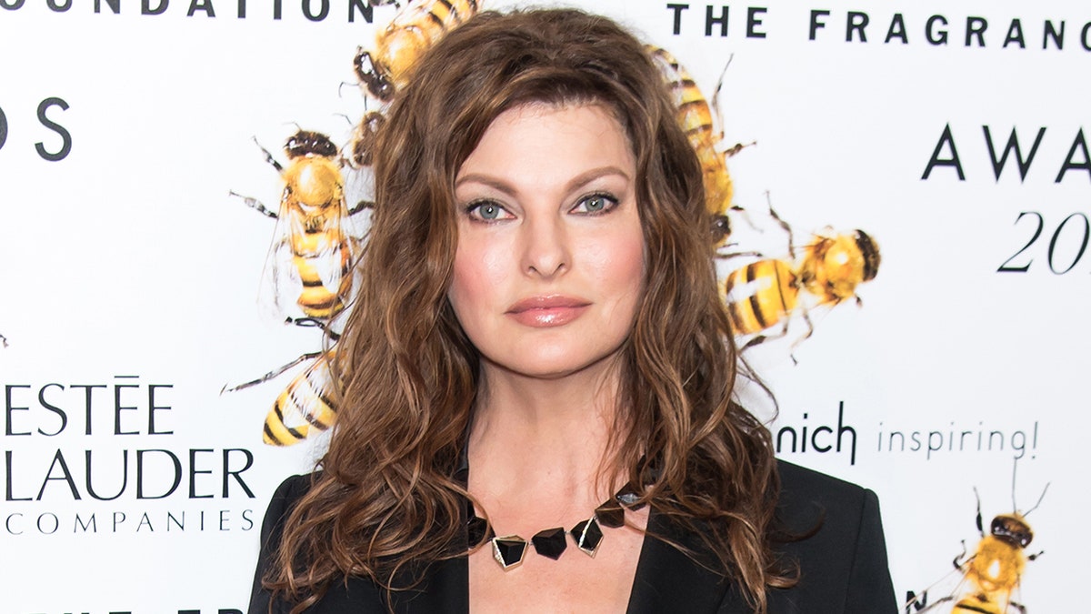 Linda Evangelista poses on the carpet in a black blazer and black statement necklace in New York in 2015