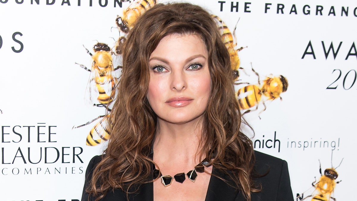 Linda Evangelista posa sul tappeto con un blazer nero e una collana nera a New York nel 2015