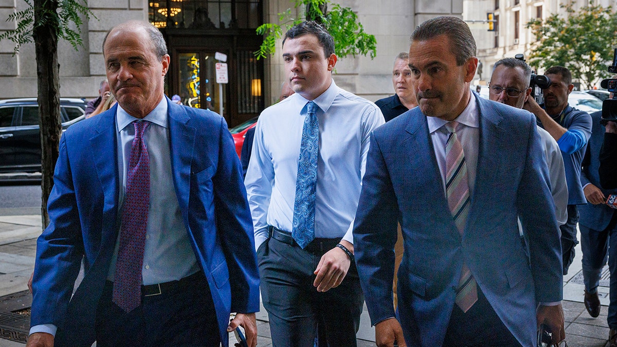 Philadelphia police Officer Mark Dial arrives at court for a hearing with his attorneys