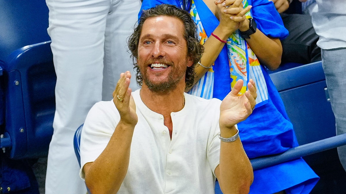 Matthew McConaughey claps in a white t-shirt while watching the US Open in New York City