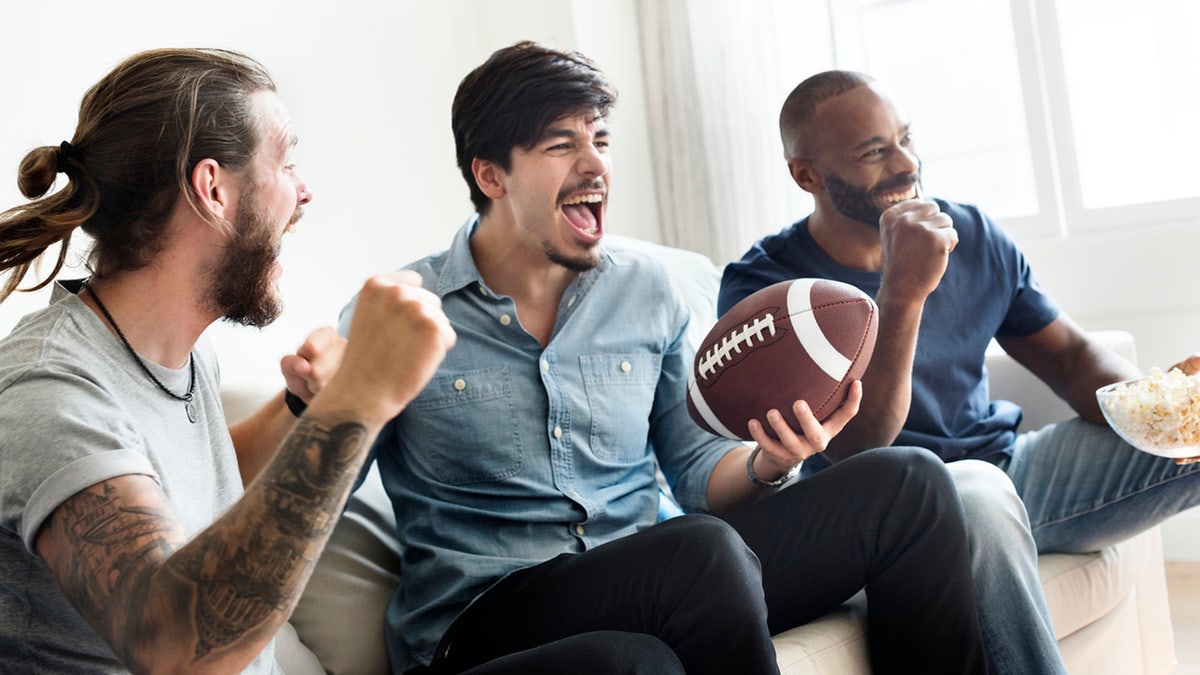 Friends cheering sport league together