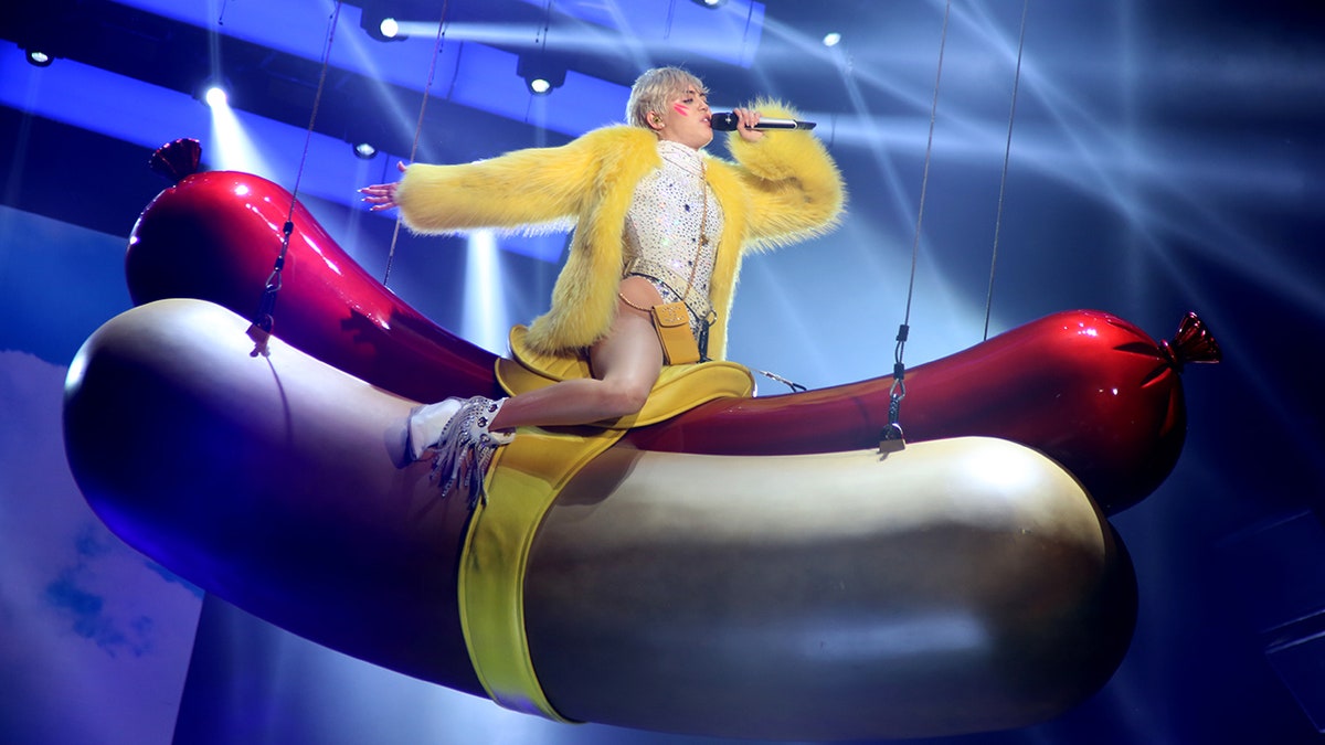 Miley Cyrus riding a hotdog onstage 