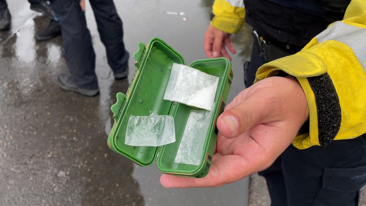 Portland police officer holding green container with suspected fentanyl