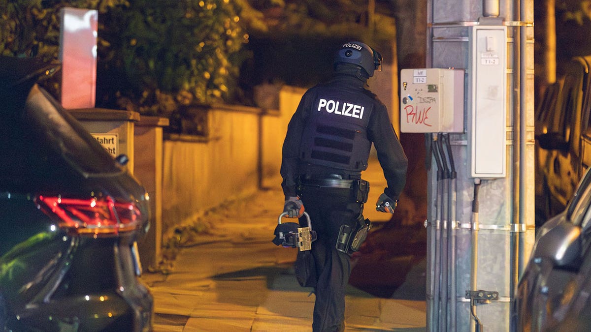 officer walks while holding hydraulic door opener 