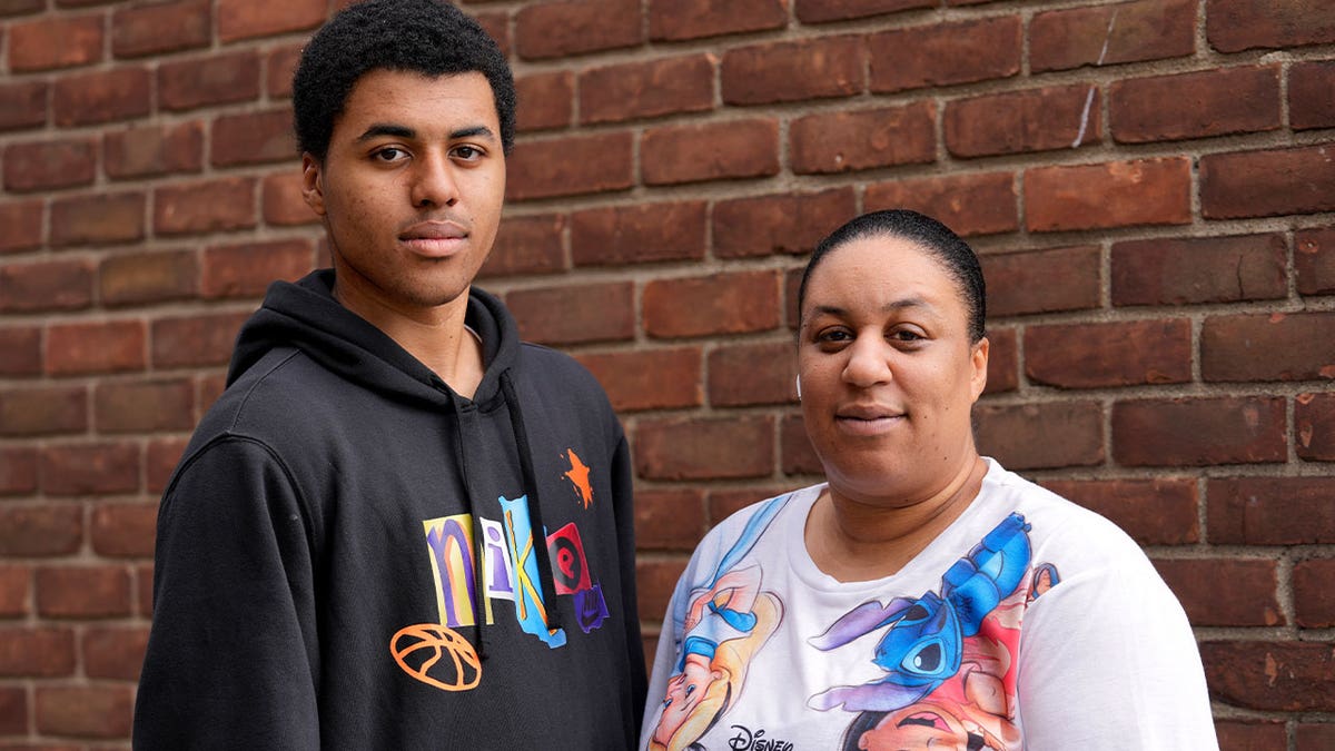 Stacy Williams stands with her son Davion, 15, in Detroit on Aug. 30, 2023. Davion attends a high school that had just laid off its college transition adviser as COVID relief aid begins to dwindle.