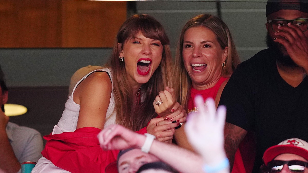 Taylor Swift segura amiga em suíte do jogo do Kansas City Chiefs e ri
