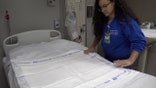 Jaime Taylor prepares a patients bed