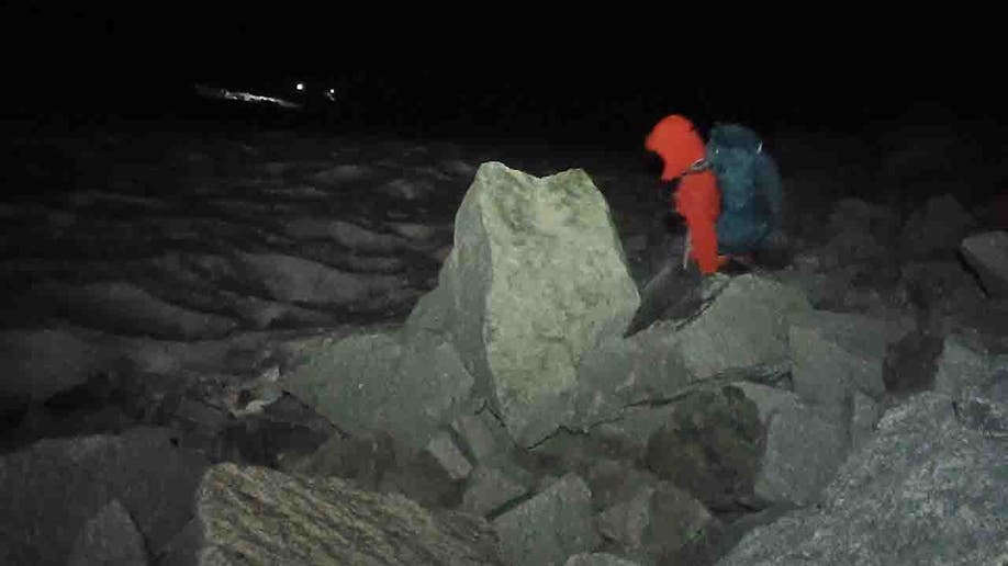 rescuers crossing rocky terrain