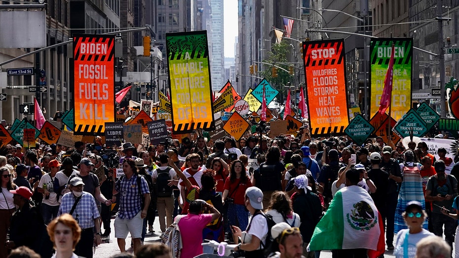 AOC joins thousands in New York climate change march with furious message for Biden