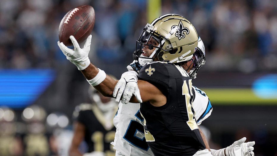 New Orleans Saints wide receiver Chris Olave wears his helmet showing an  American flag, Cuban flag and the Crucial Catch logo before an NFL football  game between the Saints and the Seattle