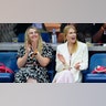 Nicole Kidman in a pink dress and white blazer claps while watching the US Open