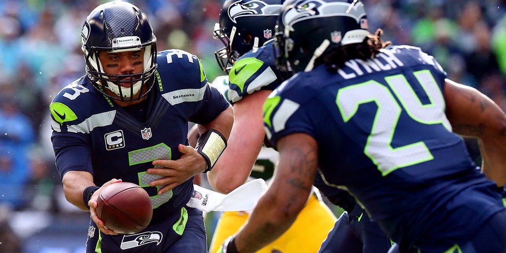 Seattle Seahawks quarterback Russell Wilson hands off to running back  Marshawn Lynch against the Green Bay Packers' at CenturyLink Field in  Seattle, Washington during a Monday Night Football gameSeptember 24, 2012.  Russell