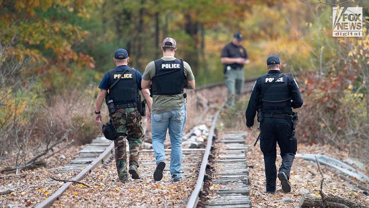 Law enforcement agents aid in the search for Robert Card along the Androscoggin River