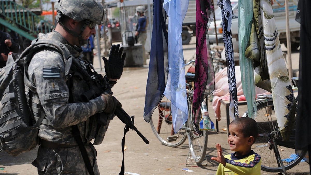 U.S. soldier waves at child in Kabul