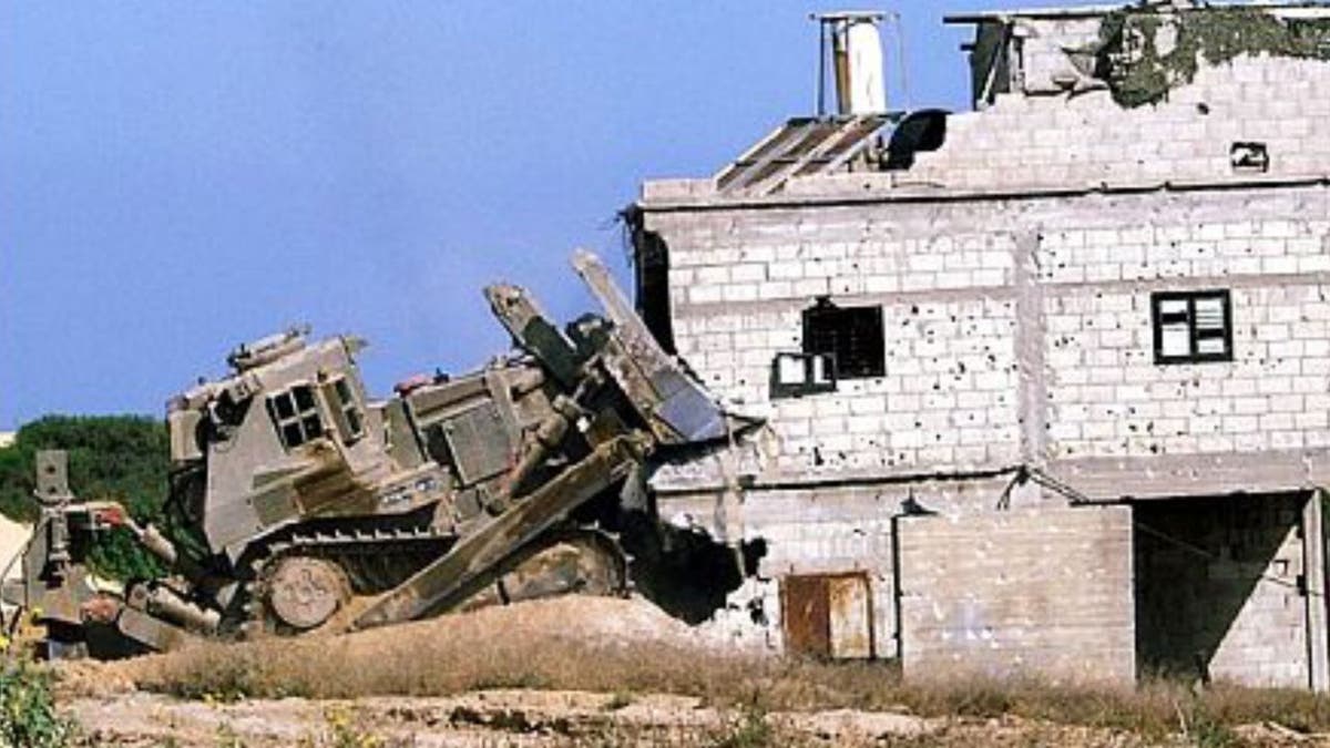 Bulldozer knocking down a building.