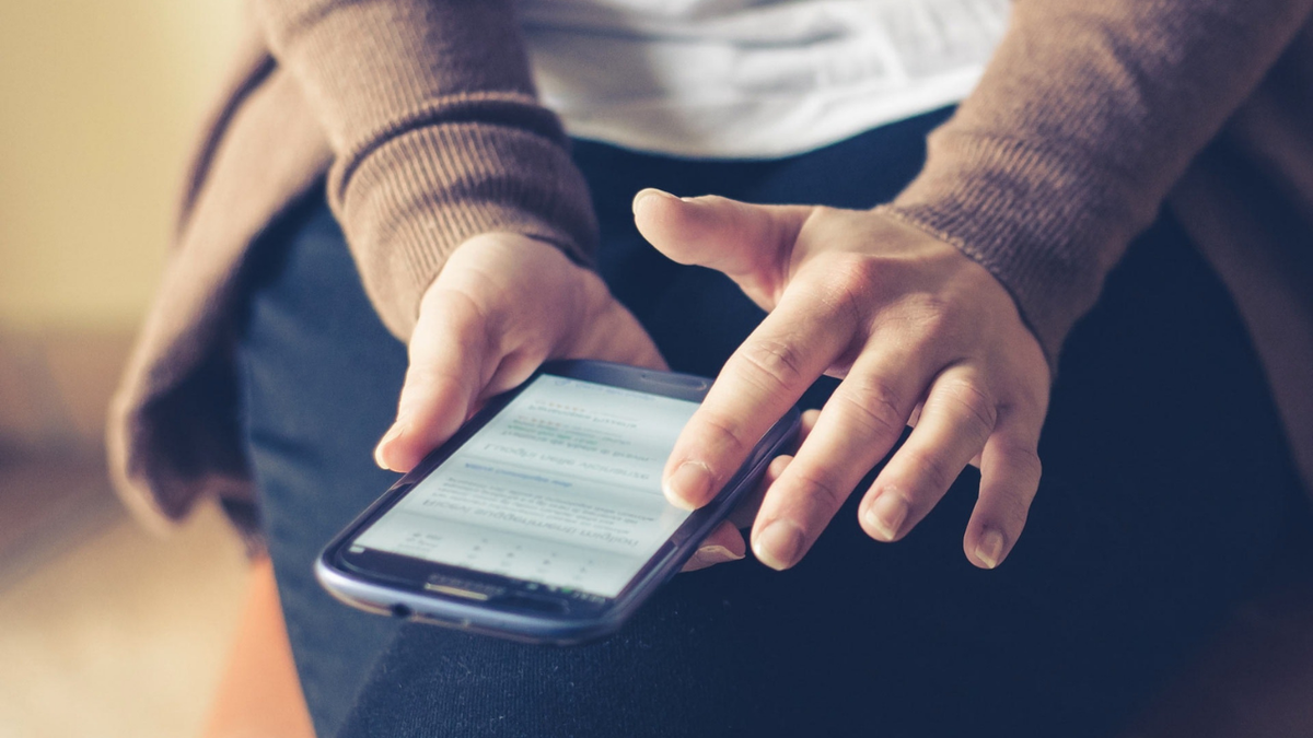 Person holding their smartphone.