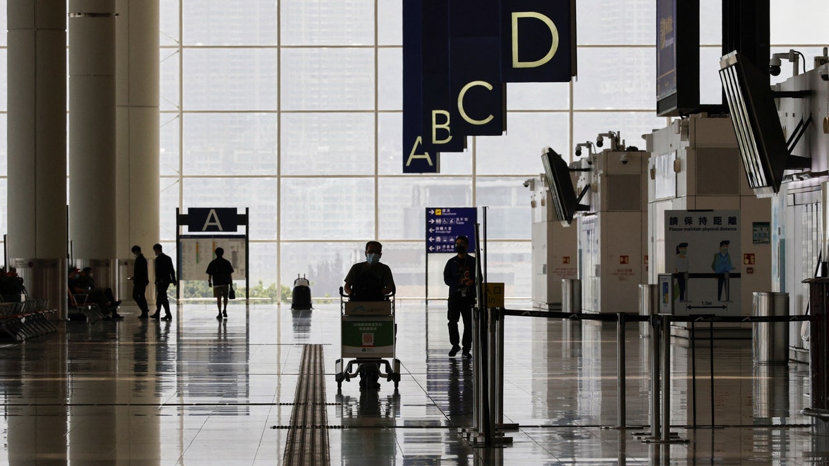 Traveler carries luggage through Hong Kong International Airport