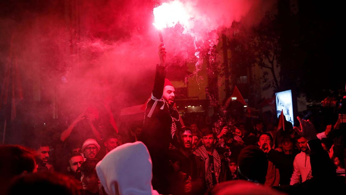 Pro-Palestinian demonstrators light flares during a protest near the Israeli Consulate as the conflict between Israel and Hamas continues, in Istanbul Oct. 18, 2023.