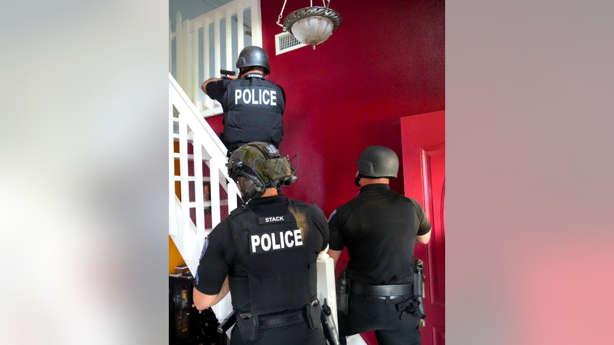 Police with guns in Steven Frasher's residence
