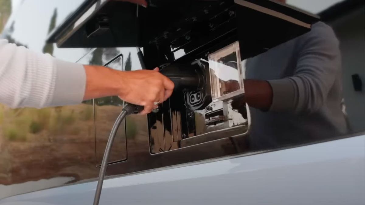 Man charging the Pebble Flow camper.