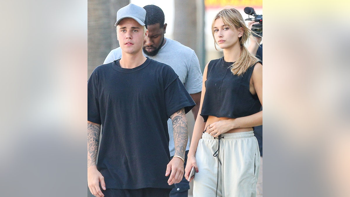 Justin Bieber in a t-shirt and baseball hat walks alongside Hailey Baldwin in Beverly Hills