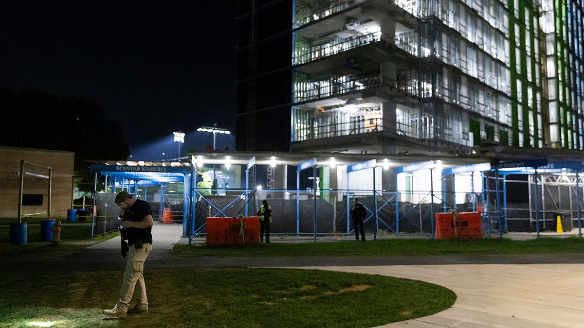 An officer pointing a flashlight at the ground