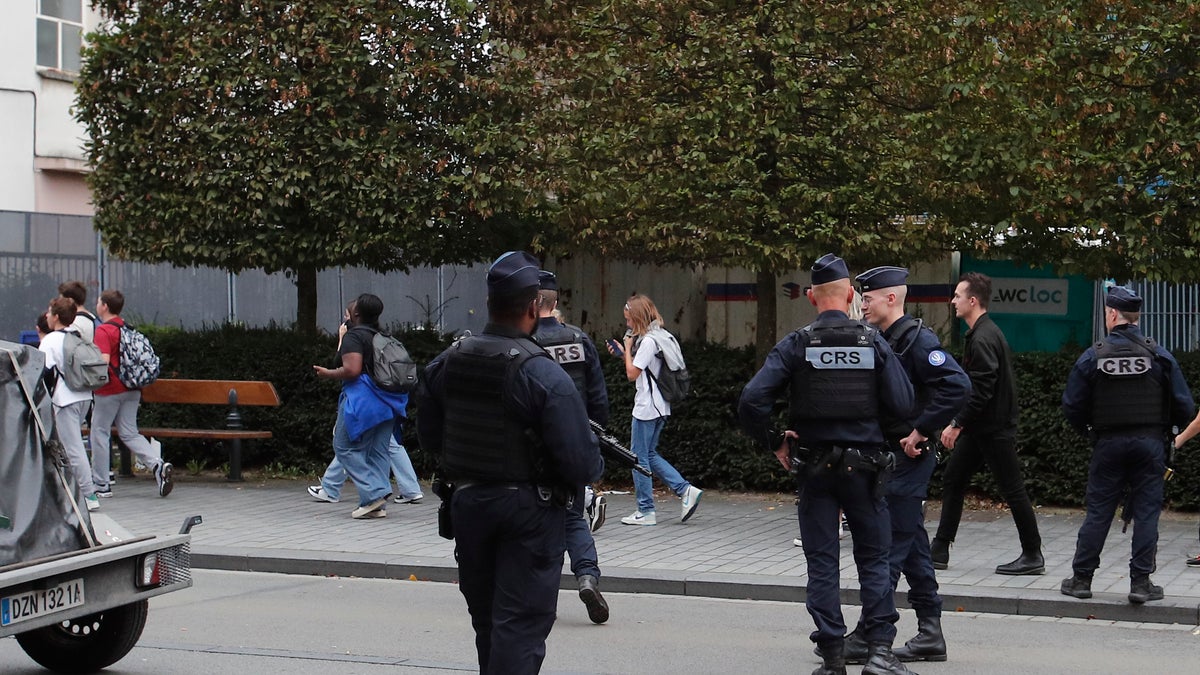 Schoolchildren leave area after man armed with knife killed teacher and wounded others at high school in France