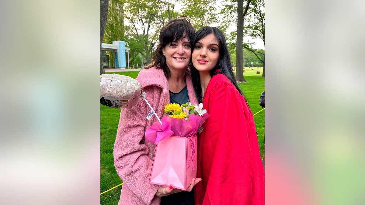 Judith and Natalie Raanan pictured together. Natalie wears a graduation gown.