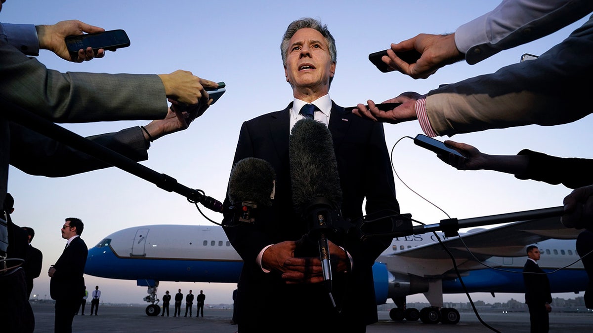 Antony Blinken talking to reporters on tarmac