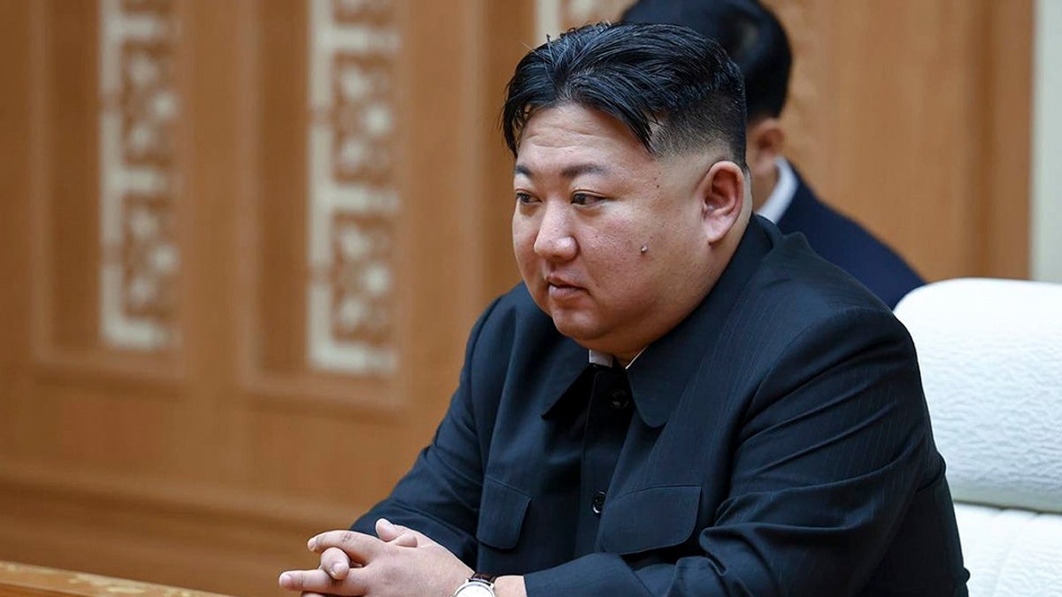 North Korean leader Kim Jong Un sits at a table