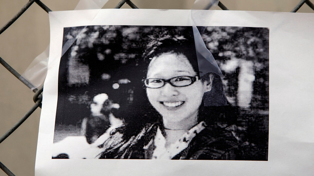 A black and white photo of Elisa Lam smiling and wearing glasses
