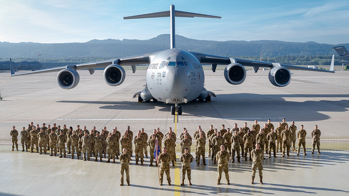 airmen in the 721st Mobility Support Squadron on tarmac for photo
