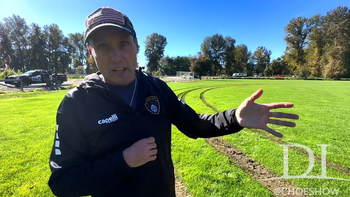 Dean Aldridge in windbreaker holding microphone